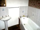 Large bathroom with full length bath, double sized shower, wash basin and toilet in Lothlorien Cottage in Hogsback, South Africa
