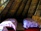 Four single beds upstairs on a mezzanine floor in Lothlorien Cottage in Hogsback, South Africa